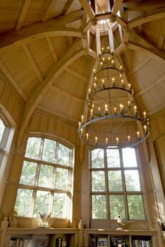 a living room filled with lots of furniture and large windows covered in string lights next to a fire place