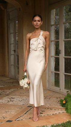 a woman in a white dress holding a bouquet