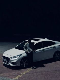 a man standing next to a white car