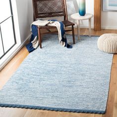 a living room with a blue rug and chair