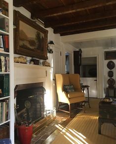 a living room filled with furniture and a fire place next to a bookshelf