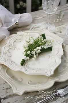 a white plate with flowers on it sitting on a table next to silverware and napkins