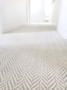 an empty room with white walls and carpet