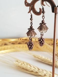 A pair of copper earrings made with pinecone charms, copper bead caps, and dark champagne crystal beads. Pine Cone Earrings, Pinecone Earrings, Pine Cone Jewelry, Autumn Jewelry, Jewelry Making Earrings, Making Earrings, Earrings Inspiration, Fall Jewelry, Pine Cone