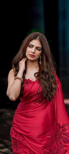 a woman in a red dress posing for the camera with her hand on her hip