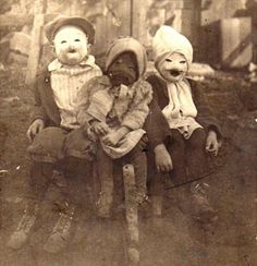 an old black and white photo shows two children with clown faces on their heads, sitting next to each other