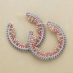 two pairs of beaded hoop earrings sitting on top of each other