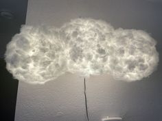 a cloud shaped like a human head is shown in the air above a white wall