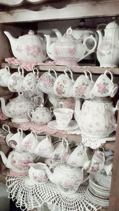 a shelf filled with lots of white and pink dishes