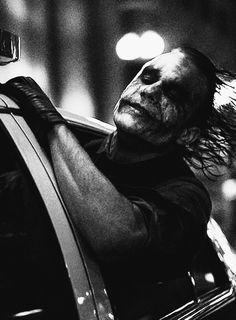 a man with his head out the window of a car, in black and white