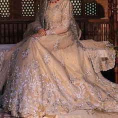 a woman sitting on top of a bed in a wedding dress