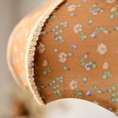 an up close view of a lamp shade with flowers on it's fabric covering