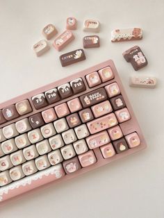 a pink computer keyboard with hello kitty stickers on the back and side panels next to it