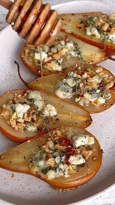 several slices of pears with cheese and nuts on them are being drizzled with honey