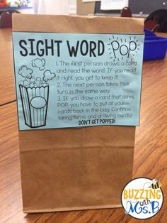 a brown paper bag sitting on top of a wooden table next to a sign that says sight word pop