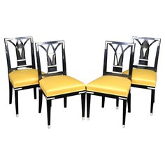 four black and yellow dining chairs with gold upholstered seats