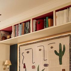 a living room filled with furniture and bookshelves next to a wall mounted book shelf