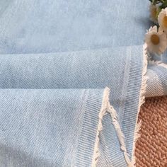 a close up of a cloth with flowers in it on a table next to a rug