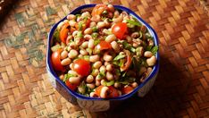 a bowl filled with beans and vegetables on top of a table