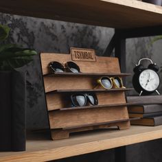 several pairs of sunglasses are on display in a store with wooden shelves and black bags