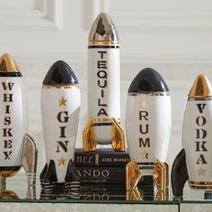 a group of white and gold rockets sitting on top of a glass shelf next to each other