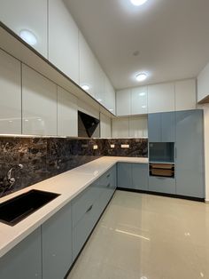 a kitchen with marble counter tops and white cupboards on the walls, along with a black sink