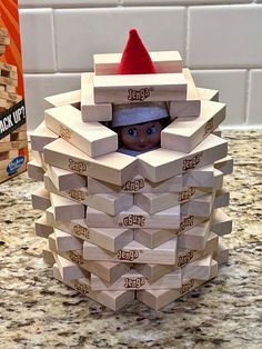 a stack of wooden blocks with a elf's head sticking out of the top