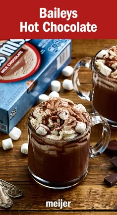 two mugs filled with hot chocolate and marshmallows on top of a wooden table