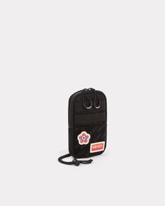 This phone pouch reflects Nigo's passion for retro and military-inspired fashion. It's a practical and distinctive accessory, which features the House's iconic badges on a hook-and-loop panel. We love the adjustable shoulder strap, meaning you can wear it in different ways: around the neck, over the shoulder, cross-body or around the waist.Cross-body phone pouch.Detachable KENZO Paris and KENZO Target badges.Monogram on the hook-and-loop panel.1 interior compartment, 1 flat pocket on the back.Ad