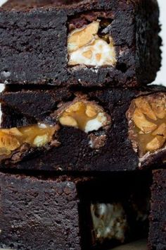 several pieces of brownie stacked on top of each other with nuts in the middle