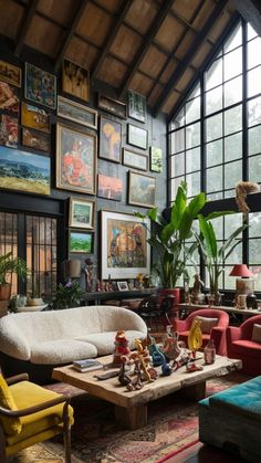 a living room filled with lots of furniture and pictures on the wall next to a window