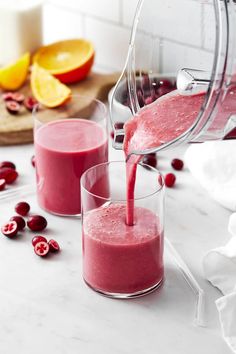 a pitcher pouring cranberry juice into two glasses