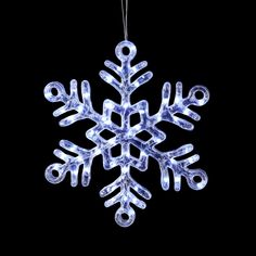 a snowflake ornament hanging from a string on a black background photo