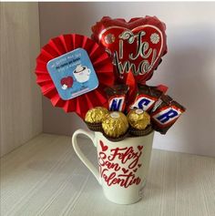 a coffee mug filled with chocolates and balloons