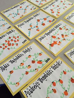 a table topped with lots of cards covered in orange and green writing next to each other