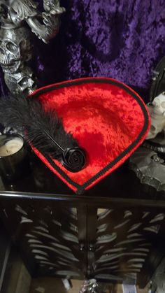 Beautiful Red Velvet Victorian Inspired Hat with a Black Rose and Black Feather. Perfect for dressing up, Afternoon Tea, formal events, Vampire Balls, and cosplay. Other styles are available in all colors. Message me for a custom order. Made in a pet friendly studio. Made to order, 3 to 5 days creation time  Check out my other listings: Black Velvet Victorian with Tassels: https://www.etsy.com/listing/1197594531/black-velvet-formal-hat-velvet-top-hat Silver Victorian: https://www.etsy.com/listing/1293744756/victorian-hat-edwardian-hat-downton Mauve Victorian:  https://www.etsy.com/listing/1293745798/mauve-velvet-hat-formal-hat-red-top-hat Burgandy Victorian:  https://www.etsy.com/listing/1094341893/victorian-hat-edwardian-hat-downton Turquoise Peacock: https://www.etsy.com/listing/11014448 Fitted Red Costume Accessories For Themed Events, Red Fitted Costume Accessories For Themed Events, Red Hats For Carnival Costume Party, Red Costume Hats And Headpieces For Carnival, Red Costume Hat For Halloween Themed Events, Red Costume Hats And Headpieces For Halloween, Red Adjustable Hat For Costume Party, Red Costume Hat, Fitted Red Costume Hats And Headpieces For Costume Party