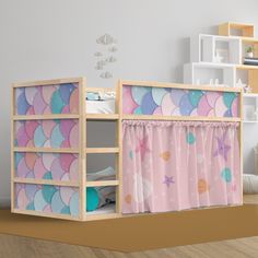 a child's bunk bed with pink and blue mermaid themed curtains on the bottom