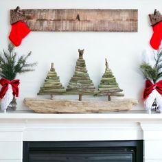 a fireplace mantel decorated for christmas with wooden trees and stockings on the mantel