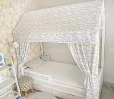 a child's bedroom with a canopy bed and white mattresses on the floor