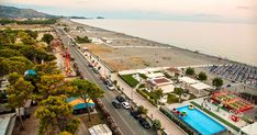 an aerial view of the beach and water park area with cars parked on the road