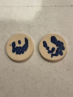 two blue and white plates sitting on top of a cloth covered table next to each other