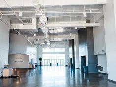 an empty building with lots of windows and white ceiling lights in the middle of it