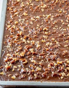 a pan filled with chocolate and nuts on top of a table