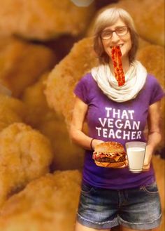 a woman eating a giant piece of food and drinking a glass of milk while wearing a t - shirt that says, that vegan teacher