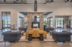 a large room with couches, chairs and tables in front of a fire place