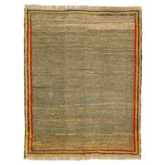 an orange and green rug with fringes on the bottom, in front of a white background