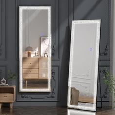 a large mirror sitting on top of a wooden floor next to a dresser and chair