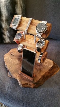 a wooden stand with watches on it and a cell phone sitting on top of it