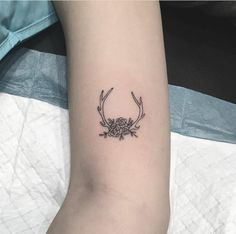 a black and white photo of a tattoo on the arm that has an antelope with flowers in it