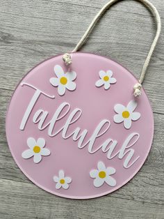 a pink sign with white daisies and the word talbulakk on it